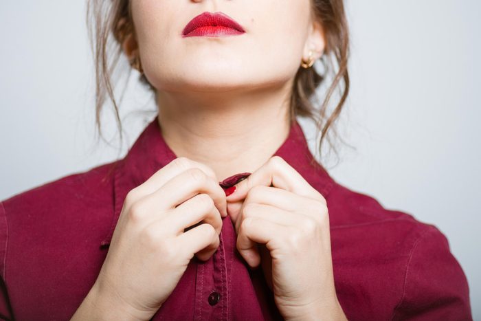 woman buttoning up her shirt