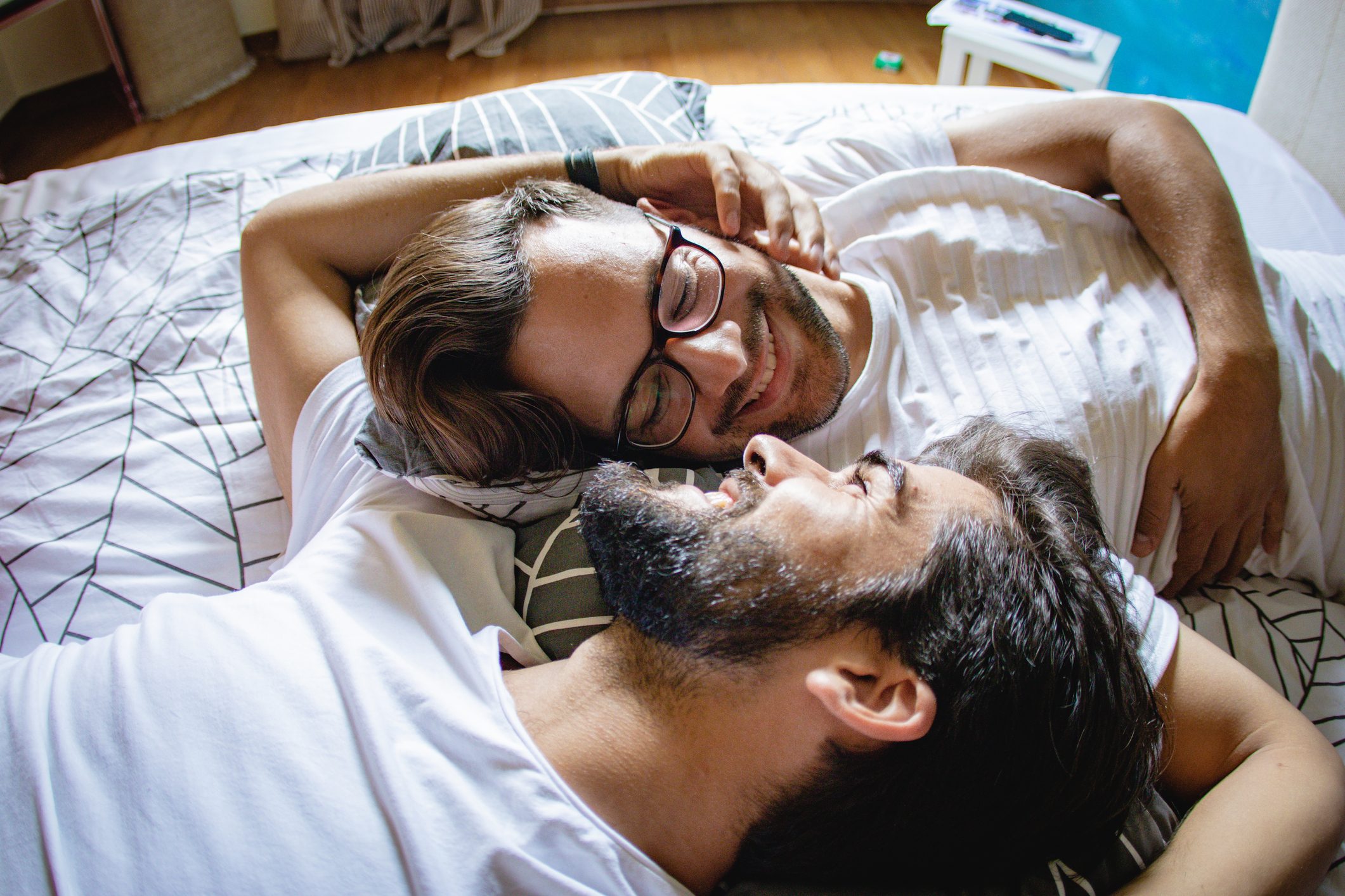 gay couple laying in bed together