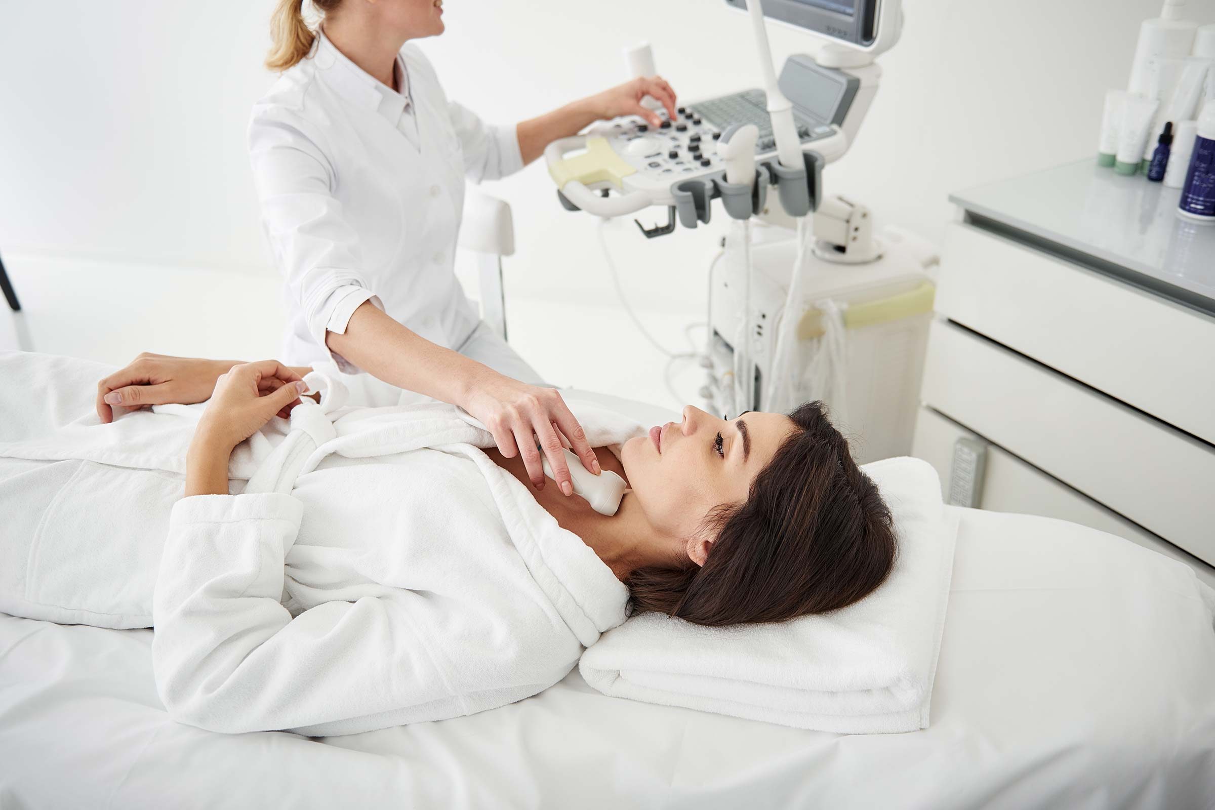 doctor administering a thyroid neck ultrasound