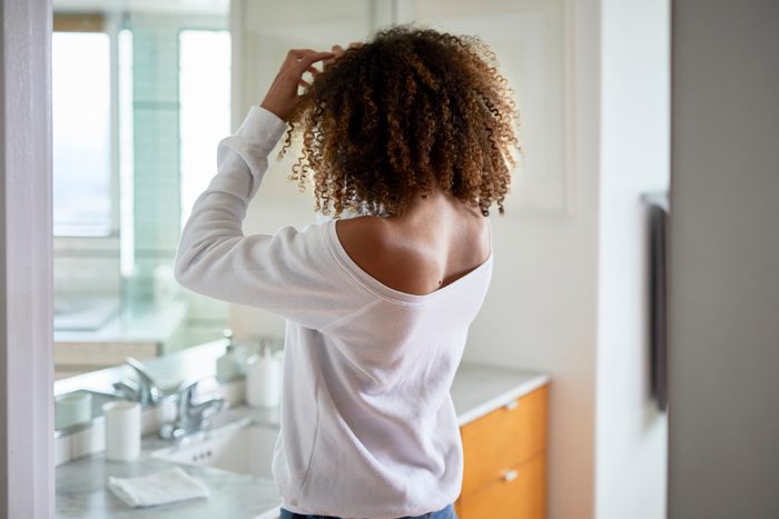 rear view of woman looking in the mirror