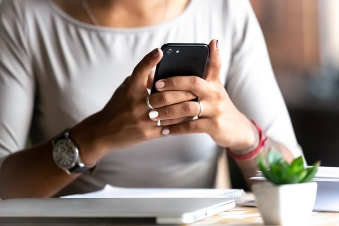 Close up woman holding smartphone, typing message, texting, chatting, female hands using cellphone, browsing mobile apps, internet, checking social networks, email, playing games on phone