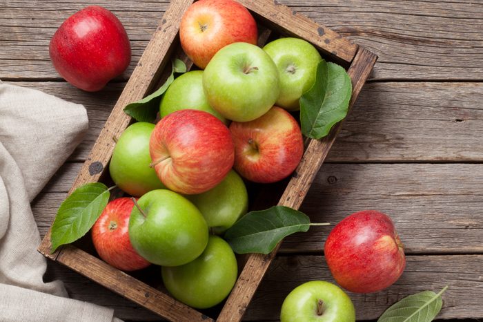 Ripe green and red apples in wooden box. Top view with space for your text