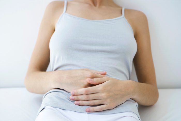 close up of woman holding her stomach