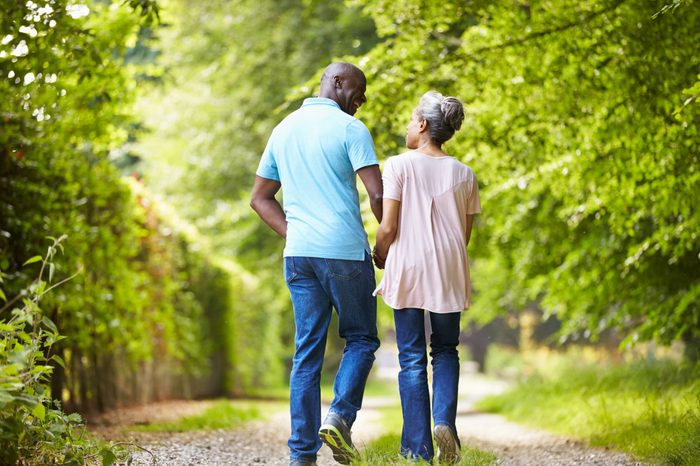 Mature African American Couple Walking In Countryside
