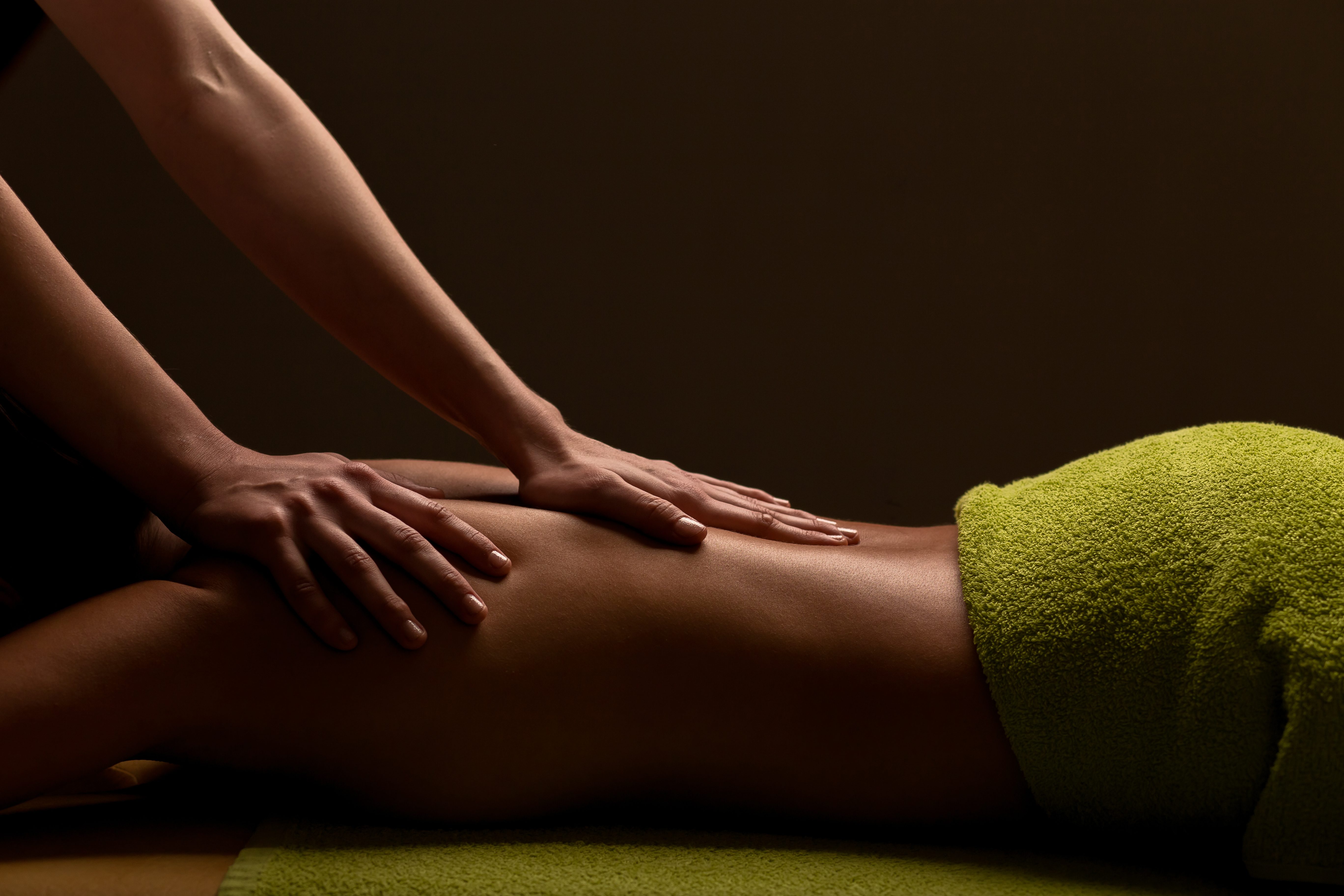 hands massaging woman's back