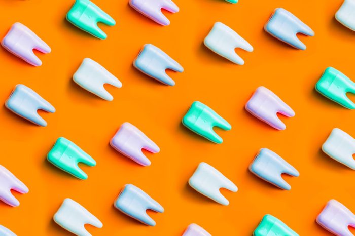 Teeth pattern on yellow bright background. Top view. Close up. Minimal dental care concept.