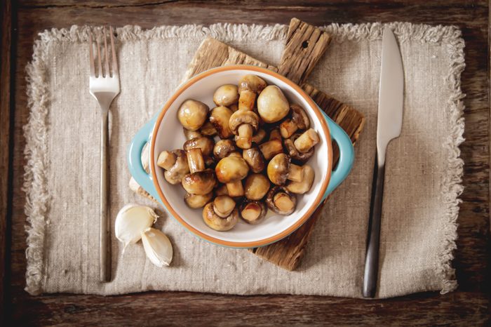 fried mushrooms with salt and pepper on a wooden background
