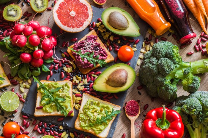 Healthy vegan food. Fresh vegetables on wooden background. Detox diet. Different colorful fresh juices.
