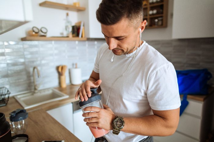man making protein shake for workout