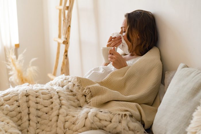 sick woman blowing her nose