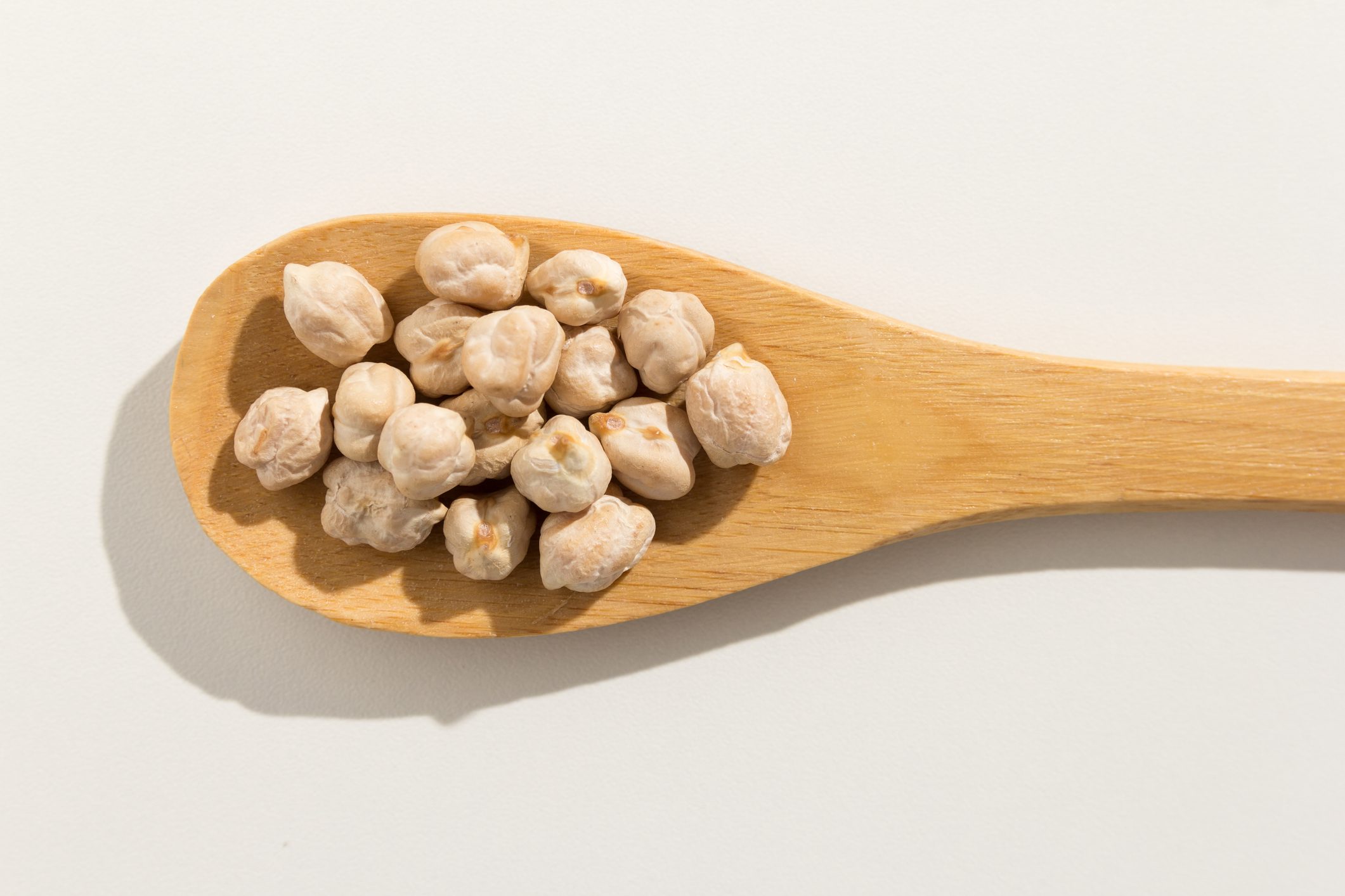 overhead shot of chickpeas in wooden spoon