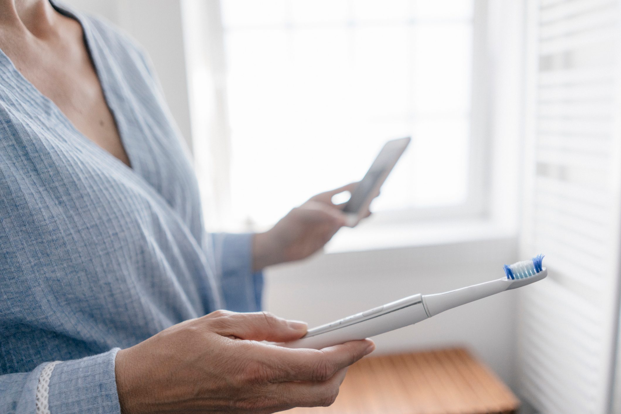 woman holding electric toothbrush