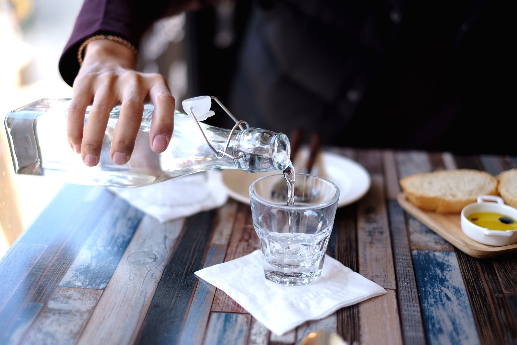 close up of person pouring water into glass