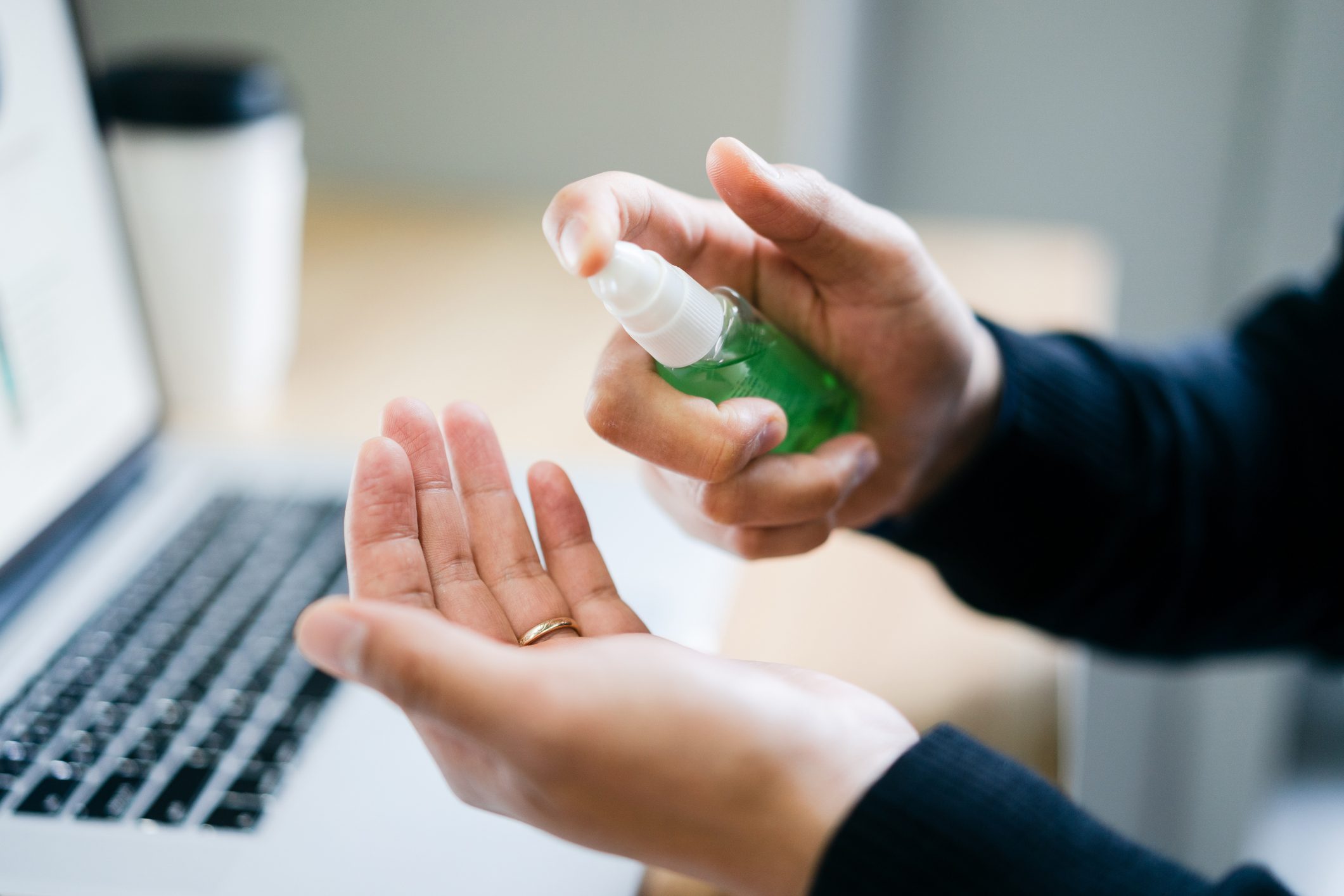 close up of man using hand sanitizer spray