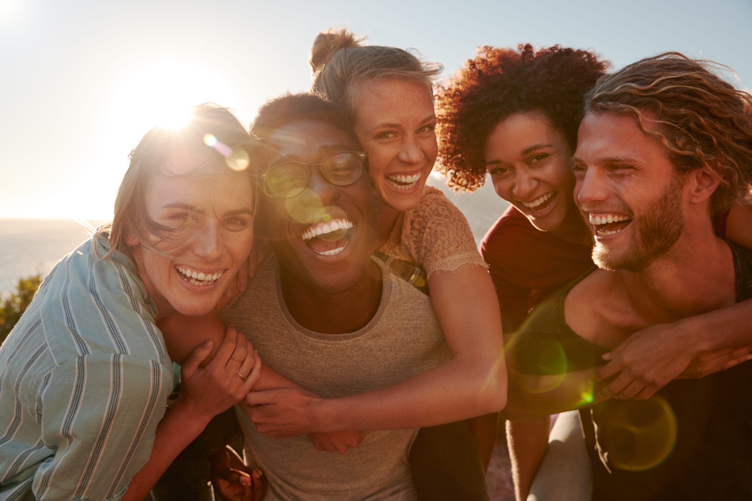group of young friends hugging and laughing together