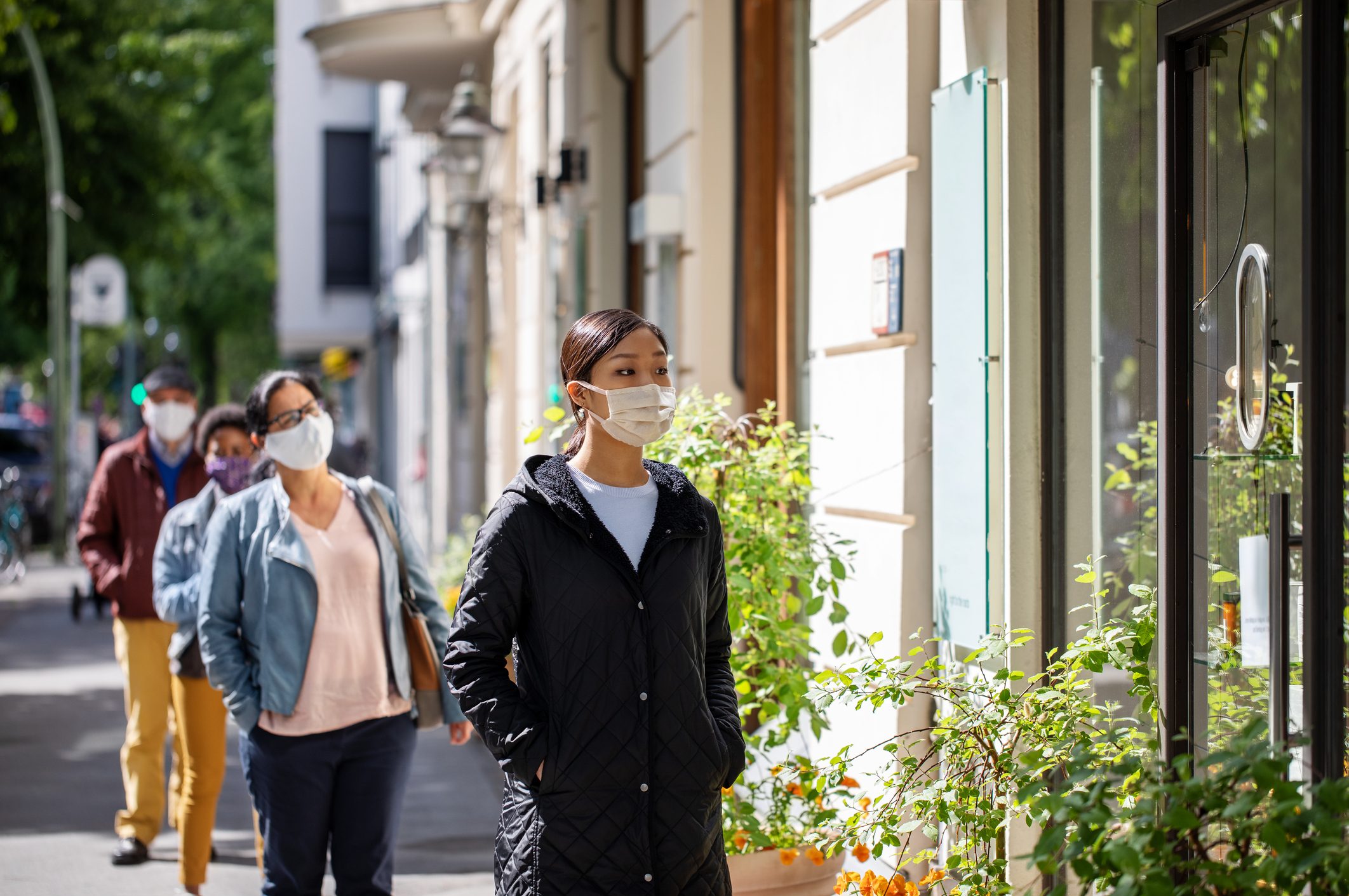 Group of people waiting in social distance outside a pharmacy