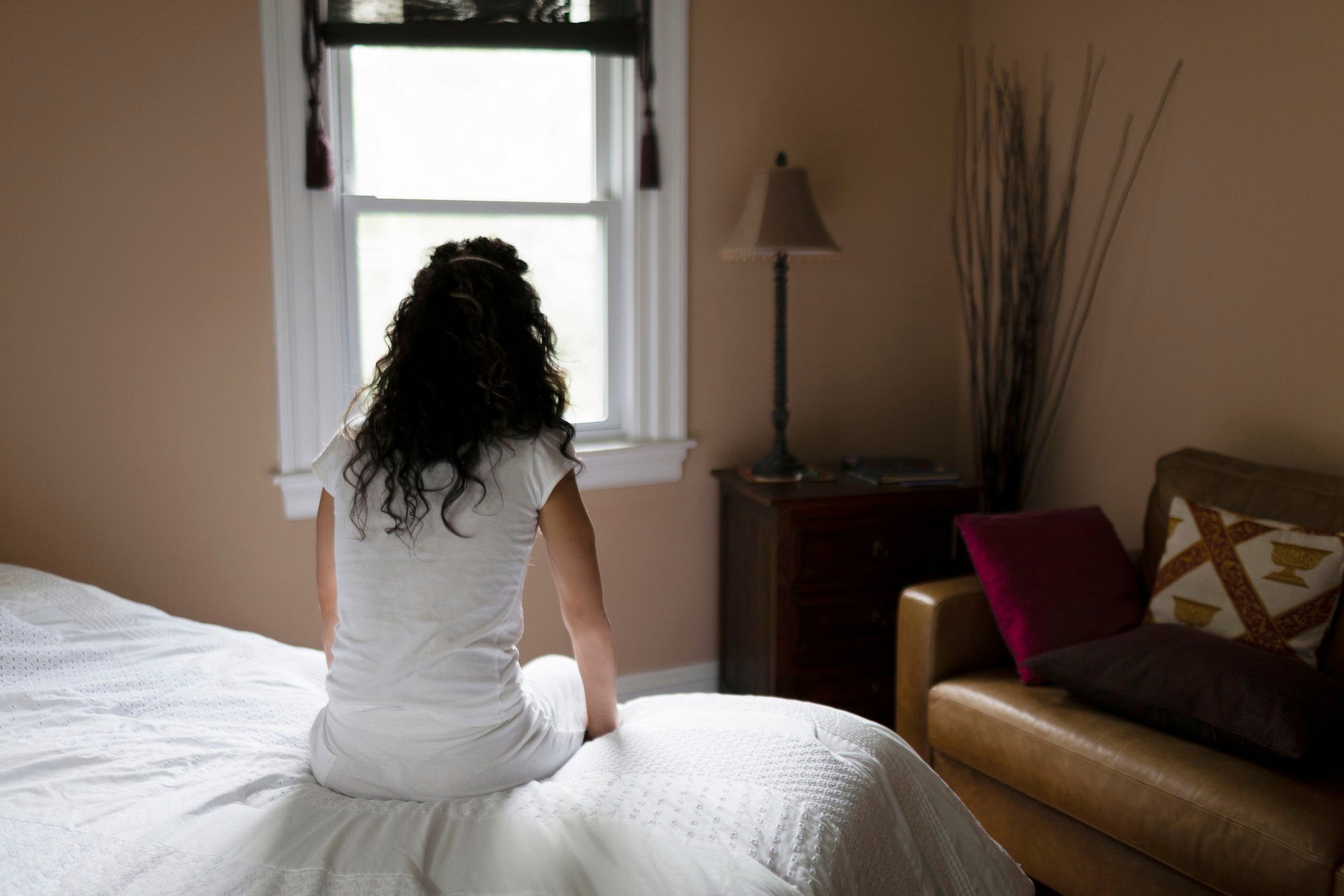 have better sex | rear view of woman sitting on edge of bed