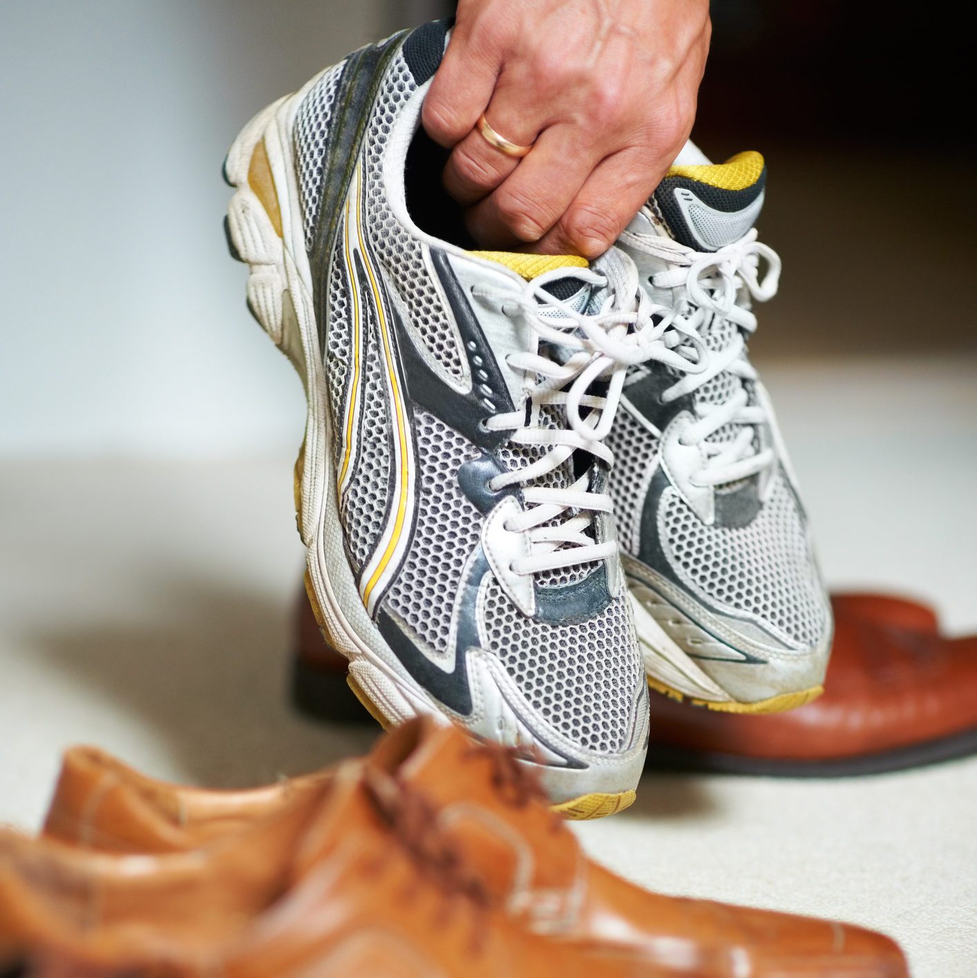 close up of man picking up a pair of sneakers