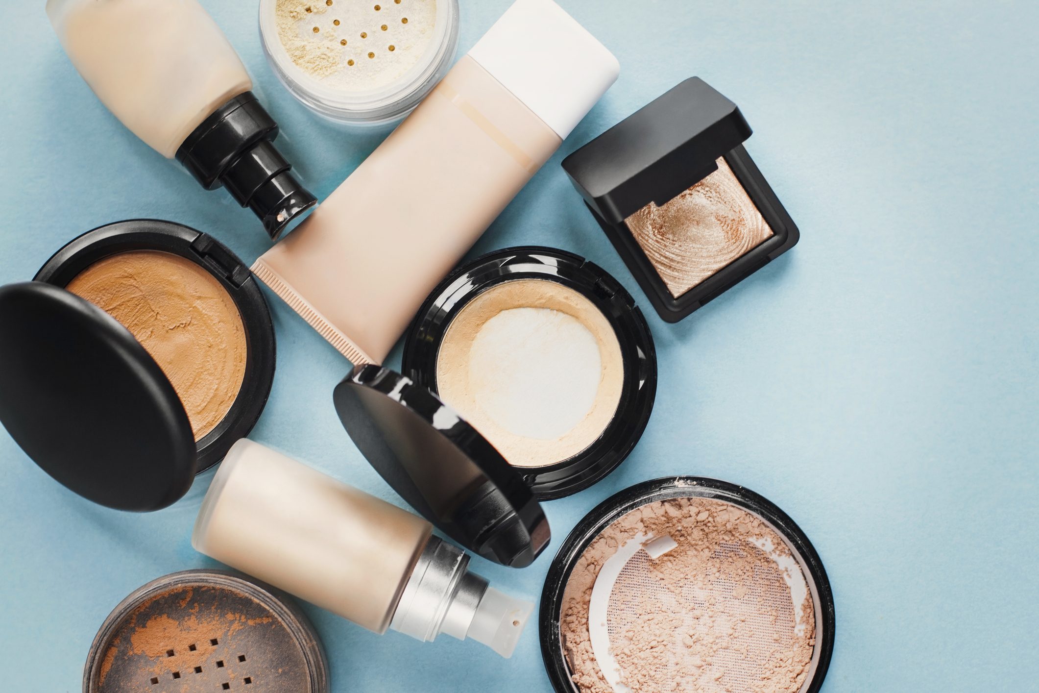 Set of decorative cosmetic. Foundations, facial powders. pastel colored. Blue background.