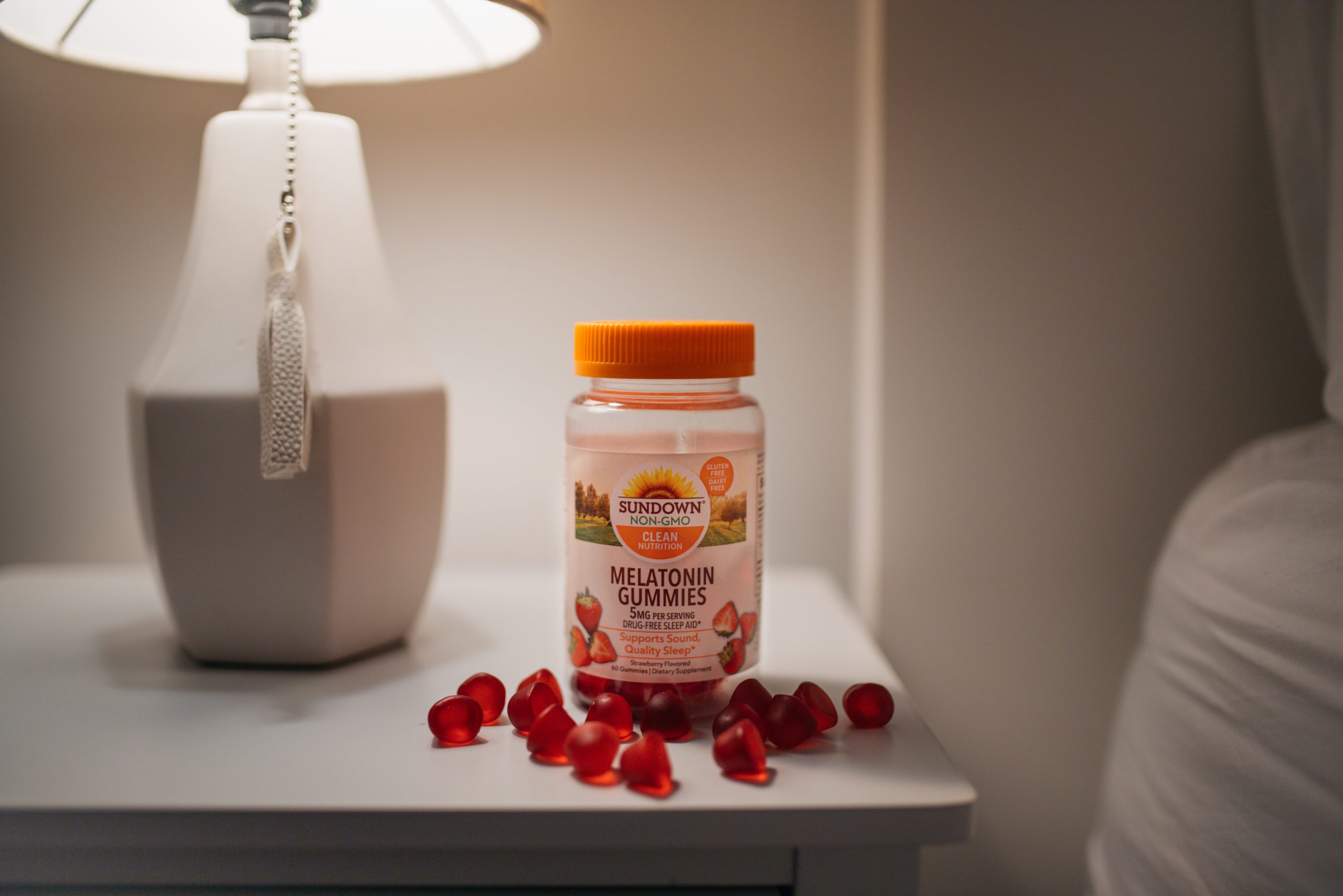 melatonin gummies on night stand with lamp