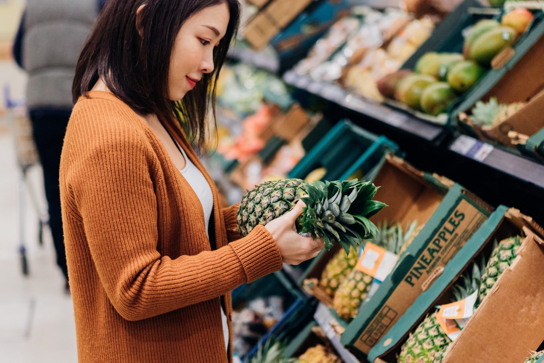 Young woman shopping for fruits and vegetables in grocery store