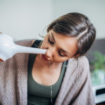 Young woman using neti pot