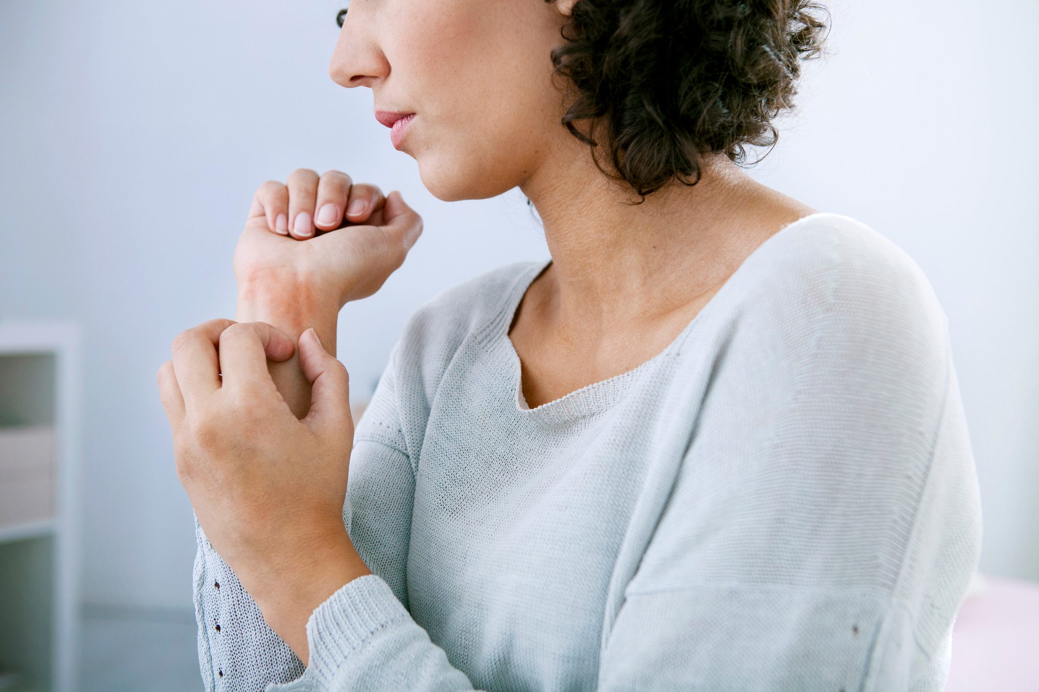 woman itching her wrist