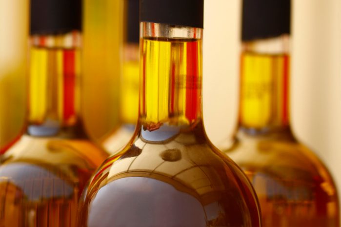 Tops of glass bottles filled with brown liquid