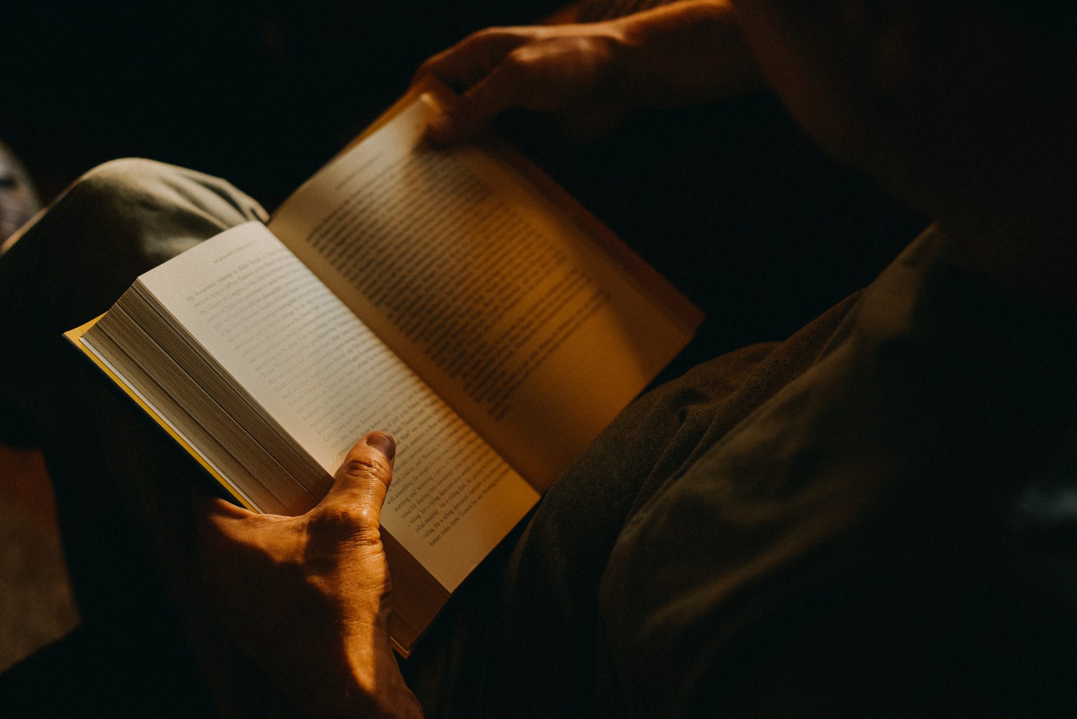 Man Reading a Book at home in the dark