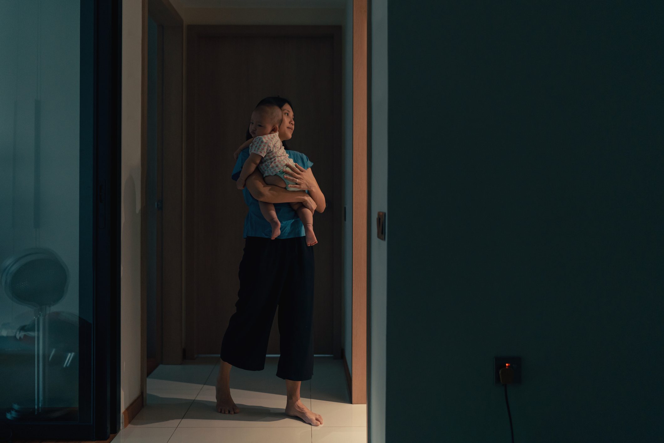 mother holding newborn baby at night