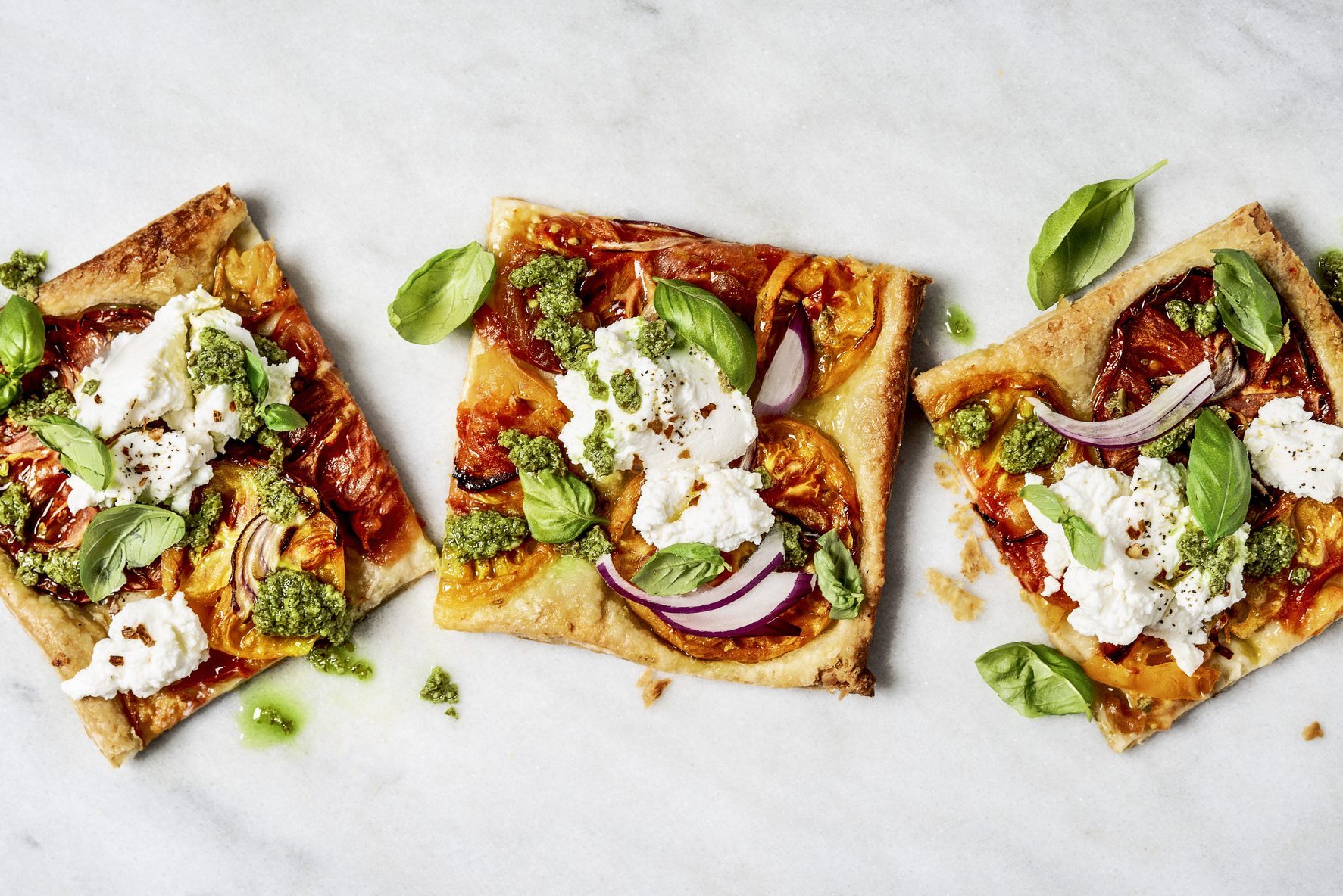 square Flatbread pizza slices on white marble countertop