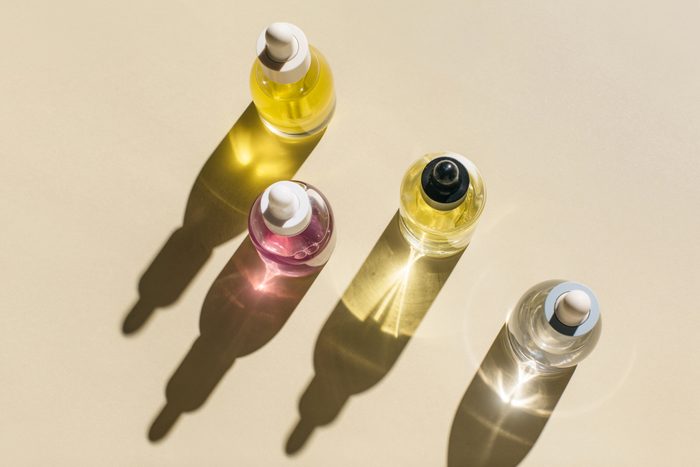 Glass bottles for cosmetic products with pipette, natural skincare and essential oil on beige background. Beauty products. Multitasking beauty, skinmalism, Skin care concept.