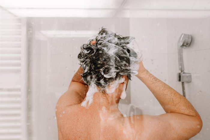 Midsection Of Man Taking A Shower In Bathroom At Home