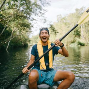 happy man kayaking down a river