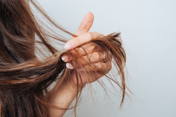 Girl holding her hair in her hand. Hair care concept. Shampoo. Haircut needed.