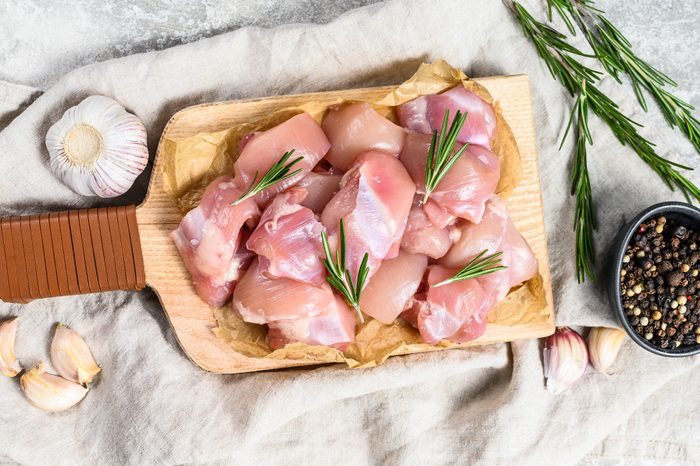chicken thigh fillet cut into cubes. Gray background. Top view