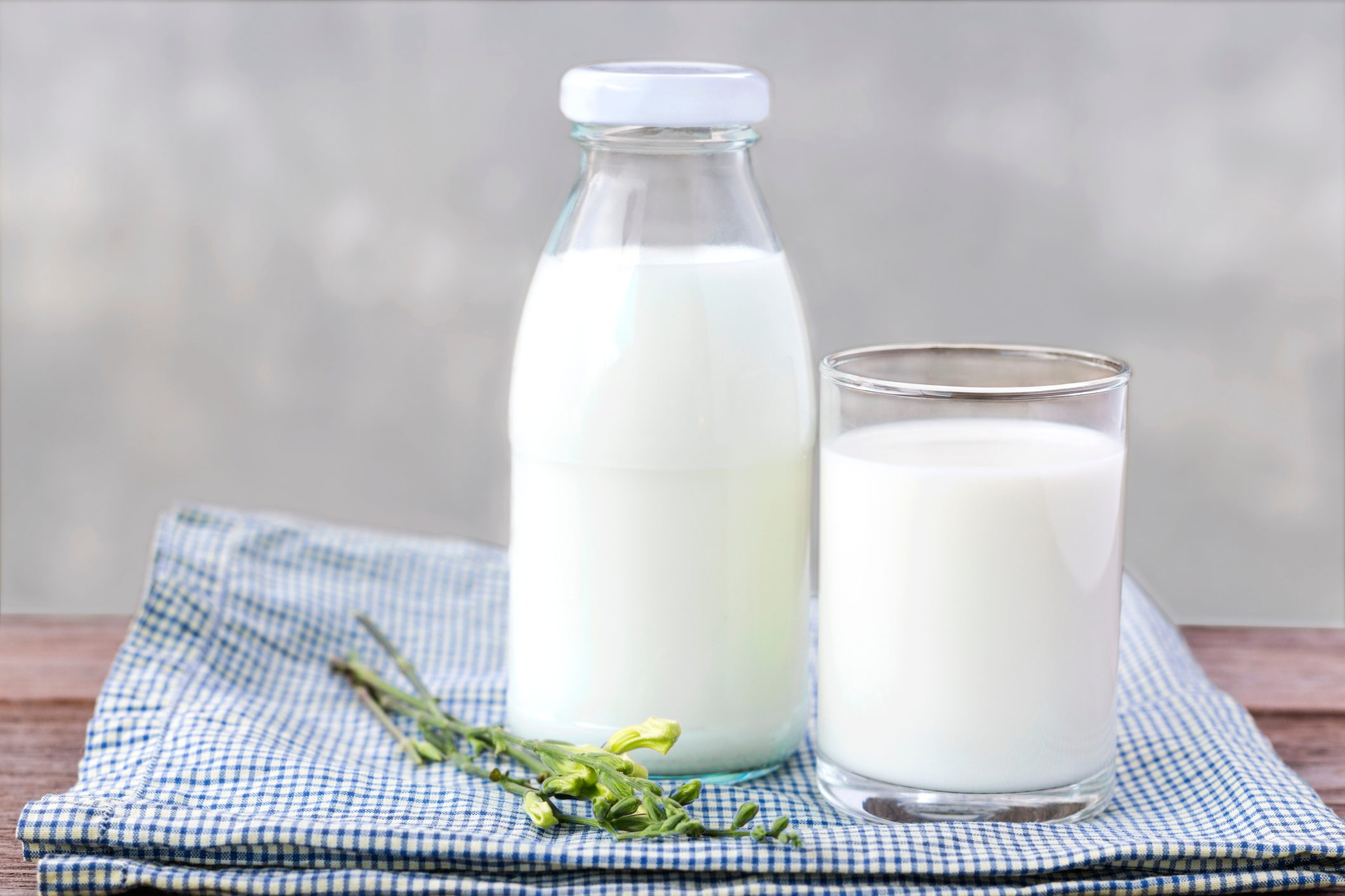 glass of milk and bottle of milk on the wood table.