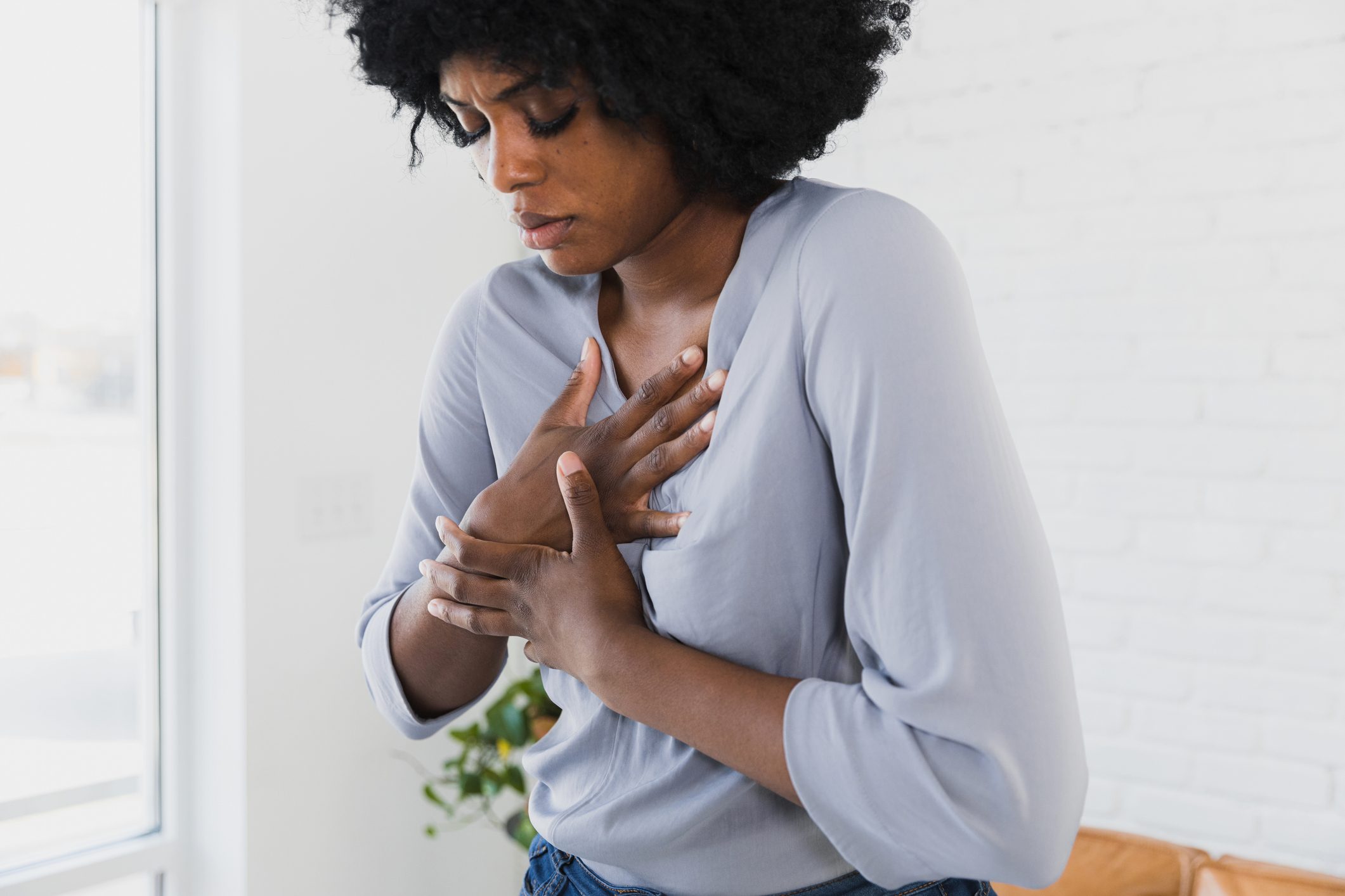 Mid adult woman holds chest