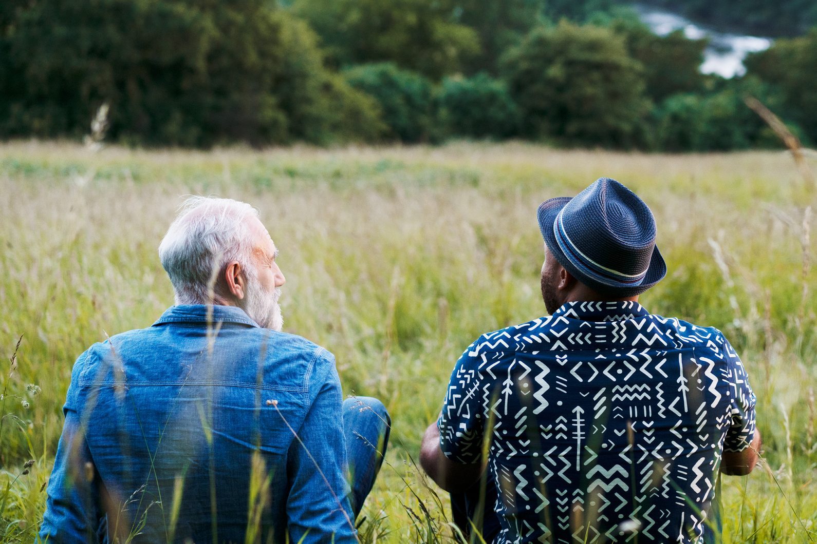 Two men sat, talking, looking at view