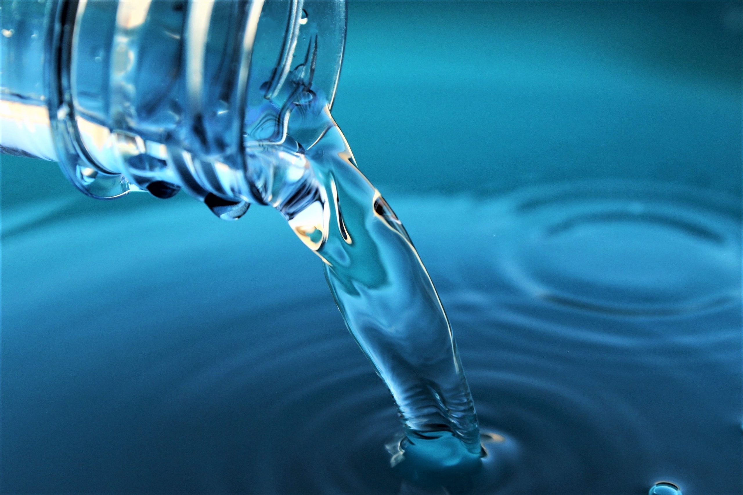 Pouring blue water from plastic water bottle