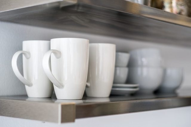 Ceramic Bowls And Mugs On Kitchen Shelf