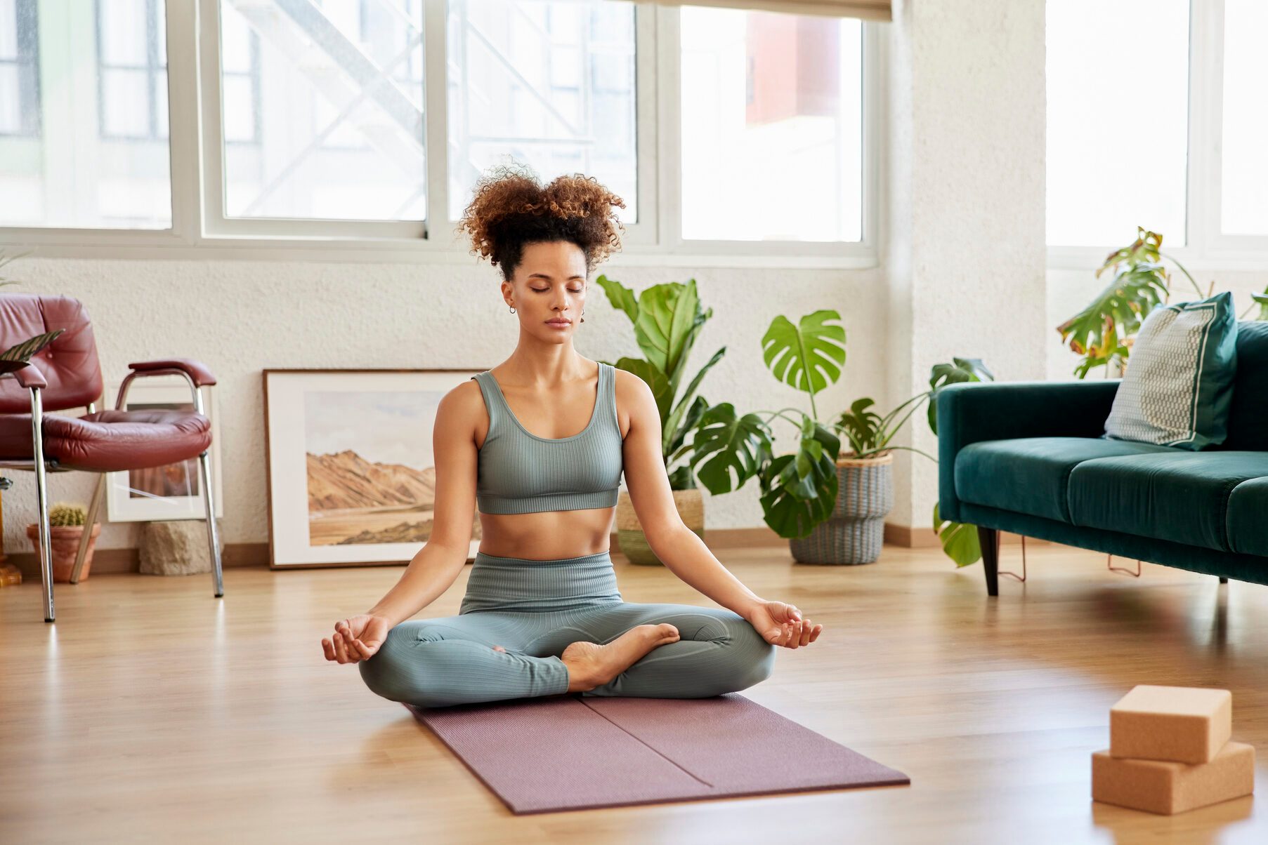 Young Woman Meditating In Living Room