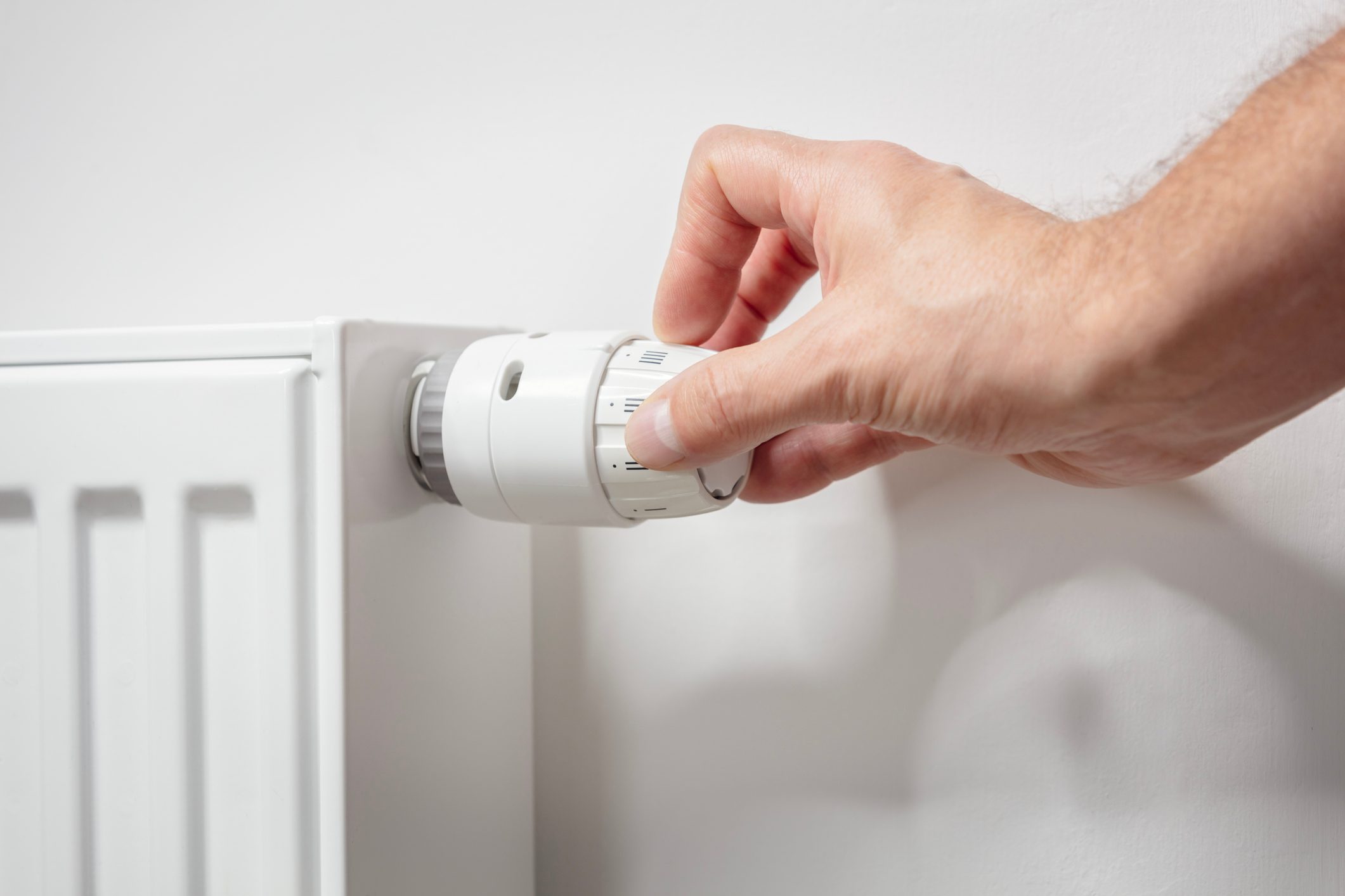 Adjusting temperature on radiator thermostat central heating control adjustment background