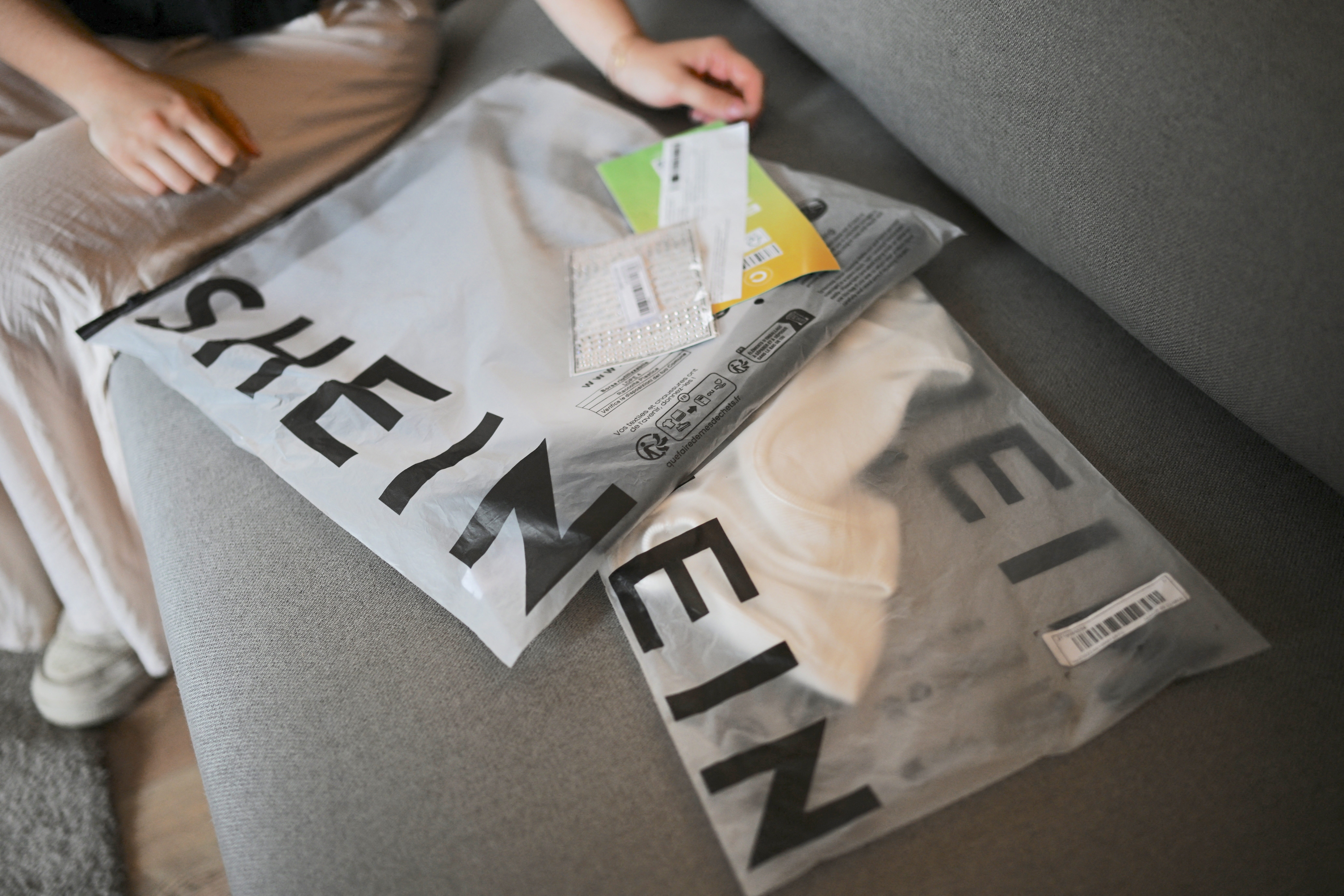 Isidora Olave, 20 years old, receives her order from fast fashion e-commerce company Shein in Santiago on November 12, 2024. Ultra-cheap Chinese online shops are causing concern in Latin America because of the unfair competition they pose to traditional commerce. (Photo by RODRIGO ARANGUA / AFP)