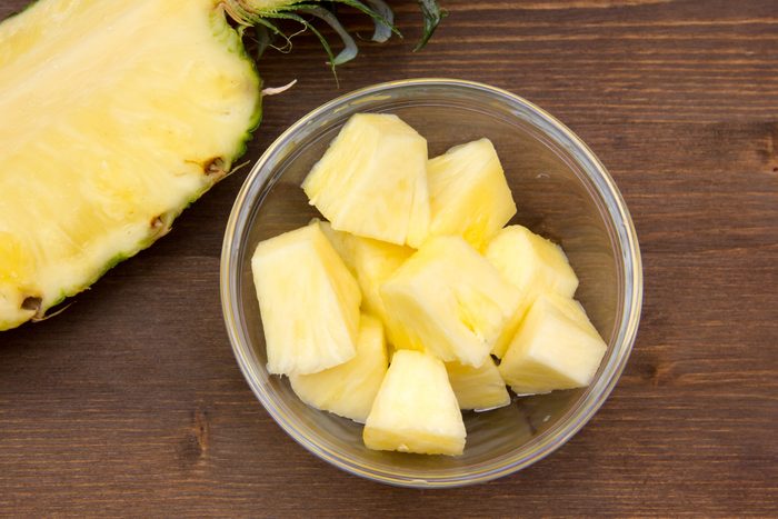 Pineapple cubes on wooden bowl on top