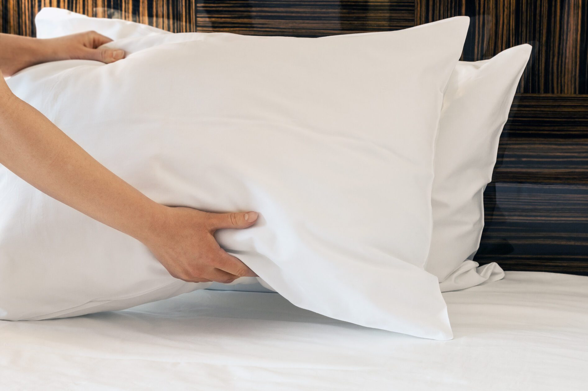 female hands corrected pillow on the bed
