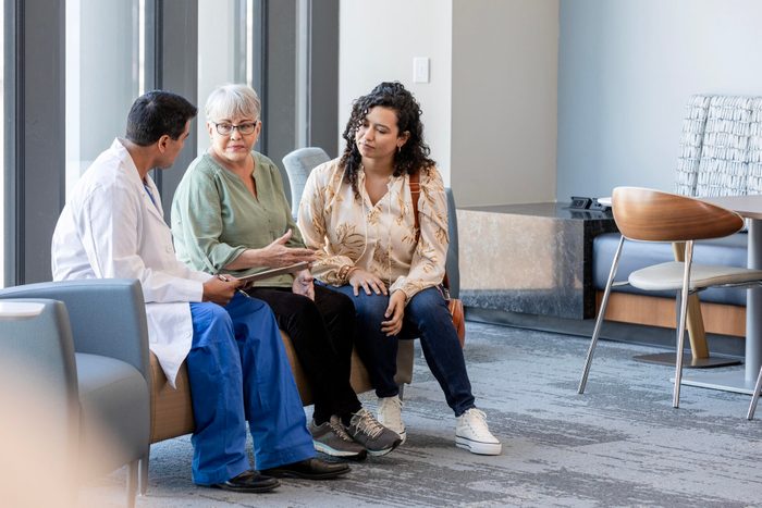 Senior woman asks male surgeon question as adult daughter watches
