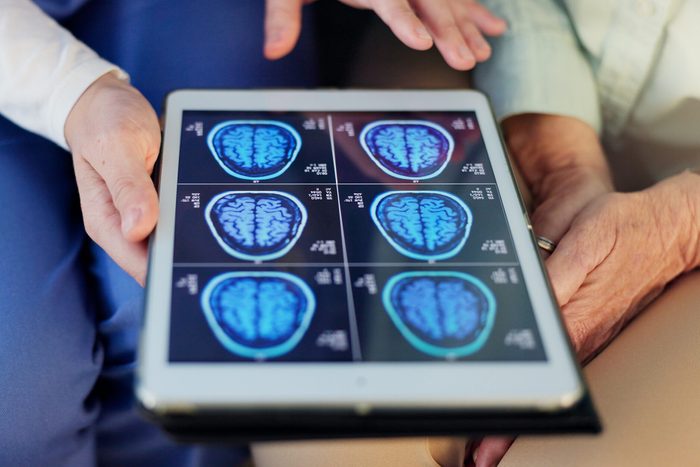 Hands, doctor and patient with tablet, brain scan and healthcare with results for MRI x ray, diagnosis and medical advice. Closeup, nurse and person with technology, cancer genome and tumor with risk