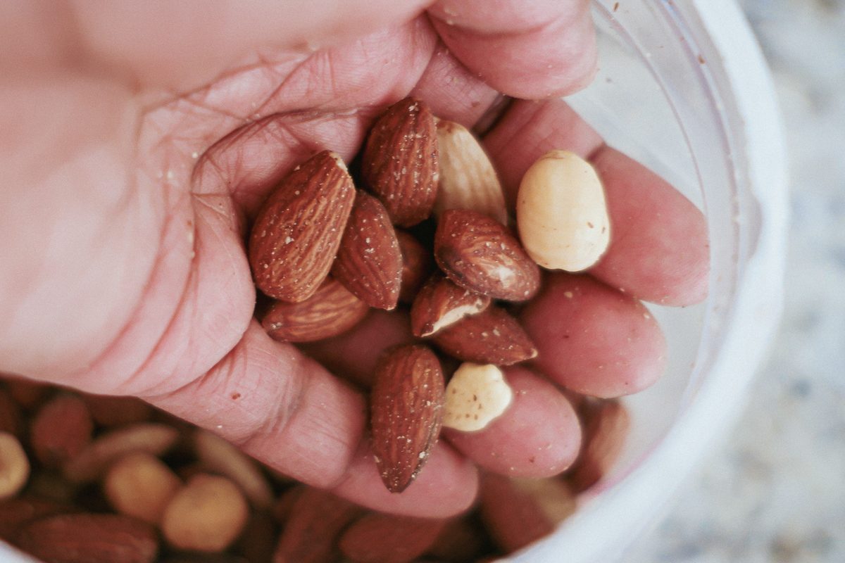 woman grabbing nuts out of container