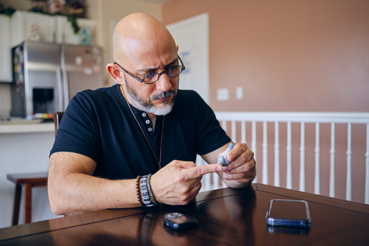 man checking blood sugar at home